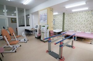 機能訓練室。複数の訓練用機器と運動補助器具が配置された広々とした施設